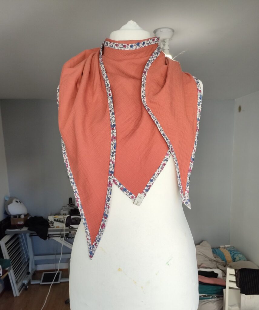 Élégance vibrante : Écharpe double gaze orange, biais fleuri. Douceur et style en 1 accessoire. Rafraîchissez votre look avec finesse.